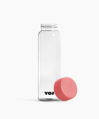 Flaska med rosa lock ståendes på sidan